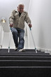 Foto: Senior mit Krücken auf einer Treppe Senior mit Krücken auf einer Treppe