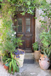 Pretty front door surrounded with flower pots in Rethymno