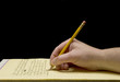 Handwriting with broken pencil point on yellow paper