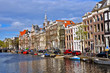 Classical Amsterdam view. Boat floats on the channel Classical Amsterdam view. Boat floats on the channel