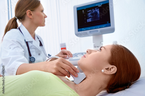 Photo: woman getting ultrasound of a thyroid from doctor woman getting ultrasound of a thyroid from doctor