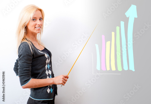 Foto: Young business teacher showing growing profit with graph on whit Young business teacher showing growing profit with graph on whit