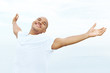 Happy young man with his arms wide open - Outdoors