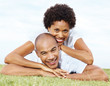 Romantic young couple lying together on lawn