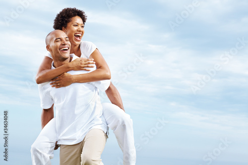 Photo: Young couple enjoying a piggy back ride Young couple enjoying a piggy back ride