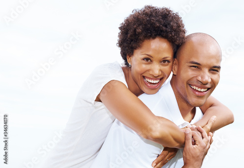 Photo: Portrait of smiling young love couple piggybacking Portrait of smiling young love couple piggybacking