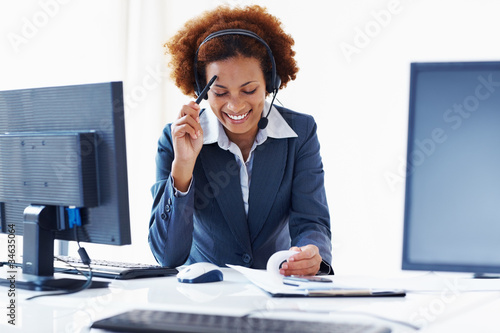 Photo: Smiling female wearing telephone headset Smiling female wearing telephone headset