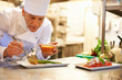 Handsome chef garnishing food