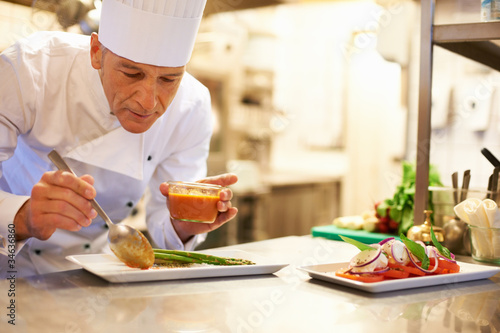 Foto: Handsome chef garnishing food Handsome chef garnishing food