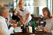 Hospitality - Waitress serving dinner to couple