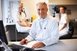 Smiling male scientist with two female assistants
