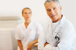 Confident male doctor with a nurse at the back