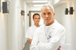 Senior caring doctor with a nurse at the back
