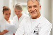 Sucessful physician with two nurses in background