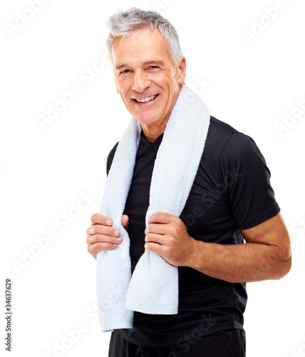Mature guy holding a towel around her neck after exercising