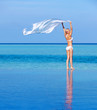 Woman standing at the poolside near ocean
