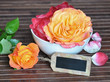 Arrangement mit Rosen und kleiner Tafel
