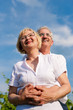 Happy mature or senior couple looking to the blue sky