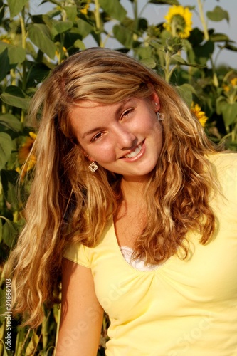 Photo: Young girl between sunflowers Young girl between sunflowers