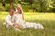 Portrait of happy newlyweds on grass in park