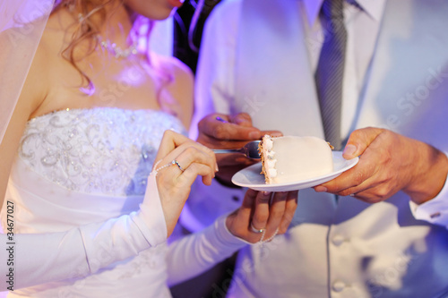 Photo: A bride and a groom are eating their wedding cake A bride and a groom are eating their wedding cake