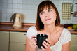young  woman, enjoying a cup of coffee in her home.