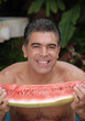Hombre comiendo sandia fresca.