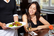 Frau schaut auf Salat im Restaurant Frau schaut auf Salat im Restaurant