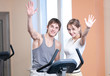 Train on machine in a gym assisted by personal instructor