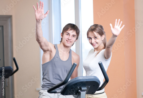 Photo: Train on machine in a gym assisted by personal instructor Train on machine in a gym assisted by personal instructor