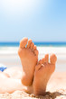 Frau liegt am Strand