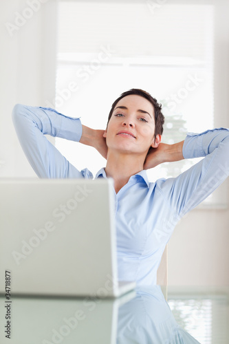 Photo: Relaxed businesswoman with a laptop looking into the camera Relaxed businesswoman with a laptop looking into the camera