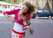 Pretty young woman with violin in the street