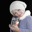 Adorable girl playing with snow globe in winter