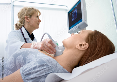Photo: woman getting ultrasound of a thyroid from doctor woman getting ultrasound of a thyroid from doctor