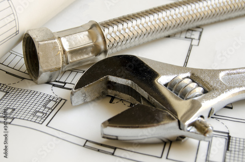 Photo: Plumbing tools over house blueprint Plumbing tools over house blueprint