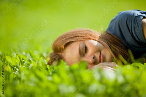Photo: girl lying on the grass and sleeping peacefully girl lying on the grass and sleeping peacefully