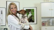 A smiling pretty young veterinarian holds a Jack-Rat Terrier