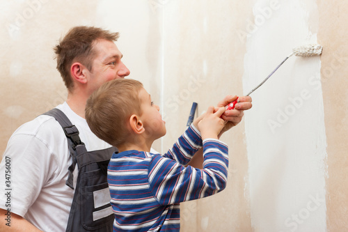 Foto: Father painting wall with child Father painting wall with child
