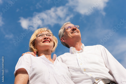 Photo: Happy mature couple looking to the blue sky Happy mature couple looking to the blue sky