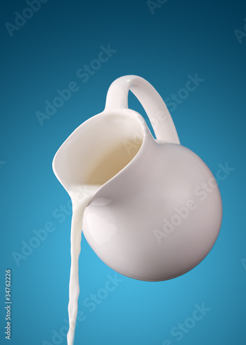 Photo: pitcher of milk on a blue background pitcher of milk on a blue background