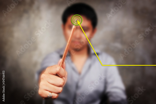 Photo: higher graph, male model drawing yellow graph line. higher graph, male model drawing yellow graph line.