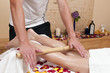Bambusmassage - Wellnesmassage -  an einer hübschen, jungen Blo