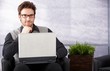 Confident businessman with laptop smiling