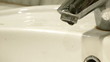 Flowing water in washbowl. Leaky faucet.