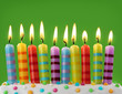 Ten colorful candles on green background