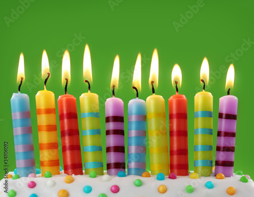 Photo: Ten colorful candles on green background Ten colorful candles on green background