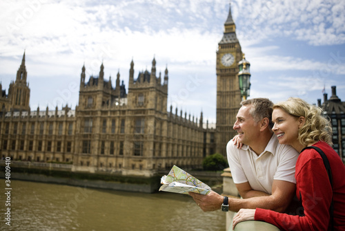 Photo: A middle-aged couple standing near the Houses of Parliament A middle-aged couple standing near the Houses of Parliament