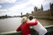 Photo: A middle-aged couple standing near the Houses of Parliament A middle-aged couple standing near the Houses of Parliament