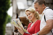 A middle-aged couple looking at a map, smiling